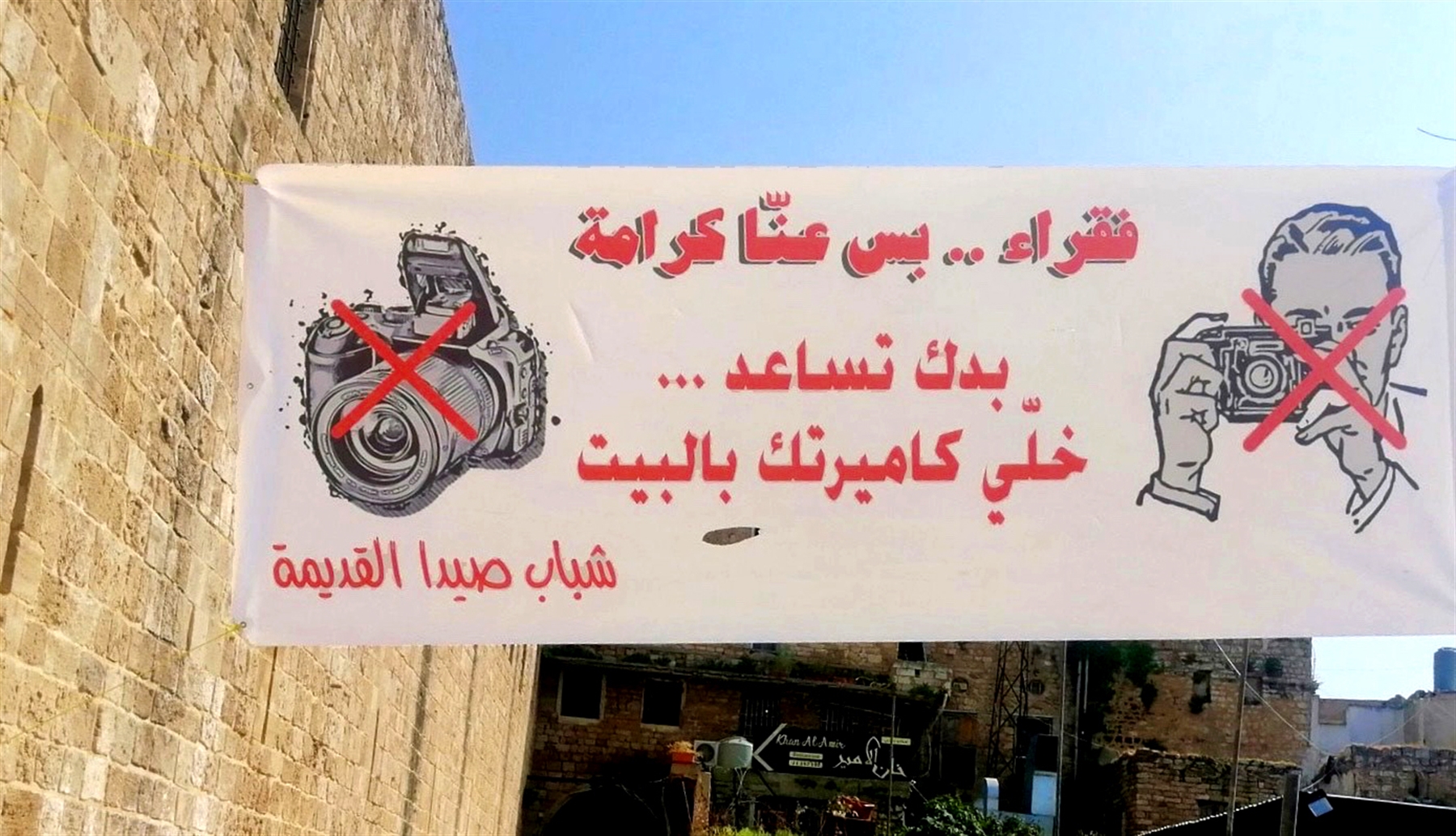 Seaside entrance to the Old City in Saida (Sidon District). The banner, placed by local citizens, targets the media and politicians emphasizing that no photos should be taken during aid distribution (Photo: Luna Dayekh, May 2020)